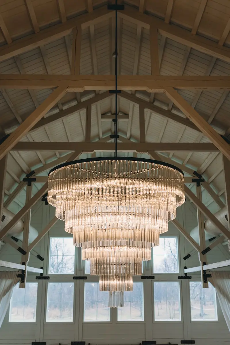 A chandelier hanging in a high timber room.