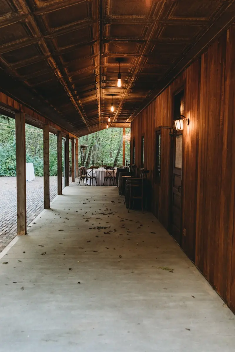 A covered walkway lined with tables and chairs.