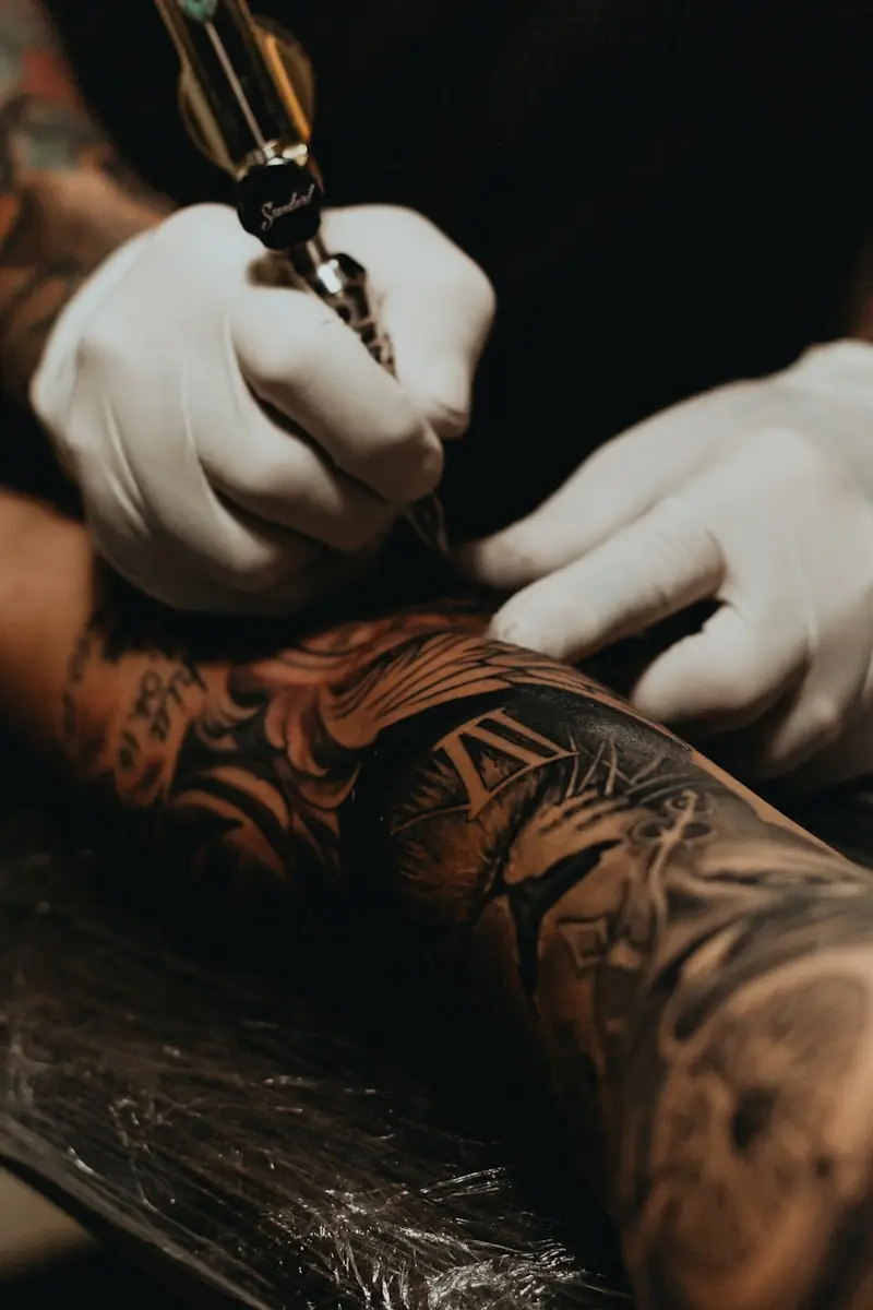An artist at work on a client's arm.